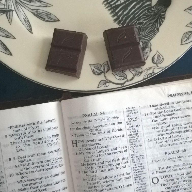 Bible opened to Psalm 84 with Green and Black's Organic Mint Dark Chocolate on zebra plate