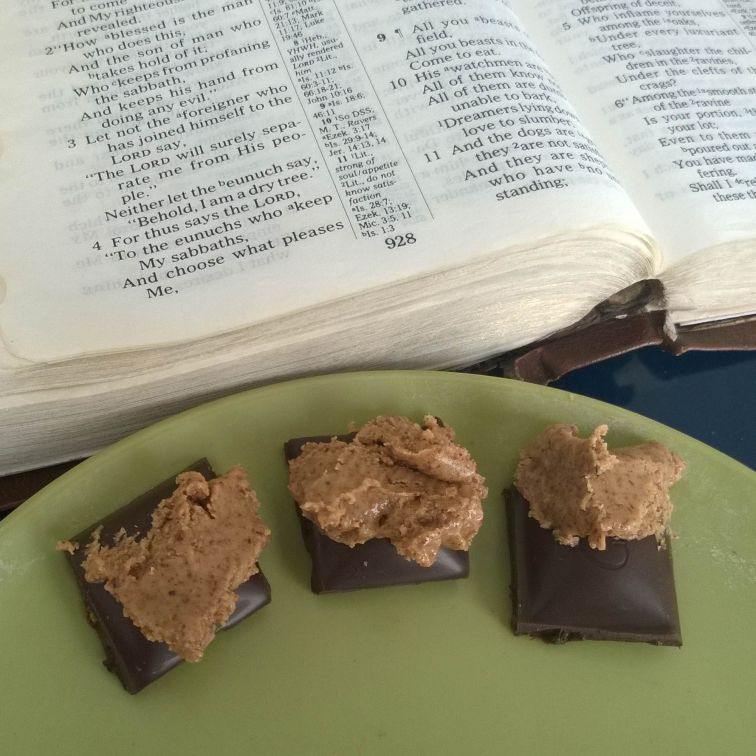 Bible opened to Isaiah 56 with Justin's Almond Butter on Chocolove Dark Chocolate Coffee Crunch